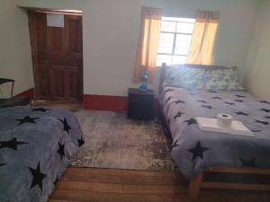 a bedroom with a bed with a blanket with stars on it at Casa de Campo-Hospedaje Munay Wasi in Tarma