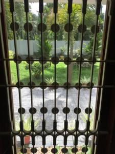 une fenêtre ouverte avec vue sur le jardin dans l'établissement White Butterfly, à Trivandrum