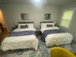 a bedroom with two beds and a yellow chair at East Point Atlanta - Spacious 5BR Retreat! in Atlanta