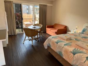 a bedroom with a bed and a table and a chair at Ulladulla Harbour Motel in Ulladulla