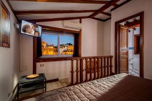 ローマにあるスイート アルティス バルベリーニのベッドルーム1室(ベッド1台、大きな窓付)