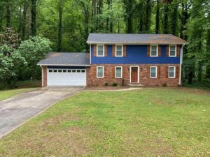 a blue house with a garage in a yard at East Point Atlanta - Spacious 5BR Retreat! in Atlanta