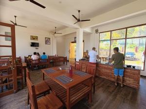 un restaurant avec des personnes debout au comptoir d'un restaurant dans l'établissement Lap Of Himalayas Resort, à Kausani
