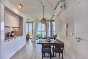 a kitchen and dining room with a table and chairs at Wave - Endless Sea View Apartment in Międzyzdroje