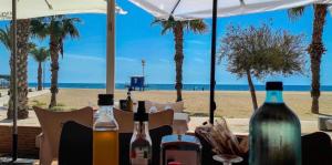 einen Tisch mit Weinflaschen am Strand in der Unterkunft Apartament Claudia II in Puerto de Mazarrón