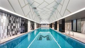 a large swimming pool with a tile ceiling at Meriton Suites Liverpool in Liverpool