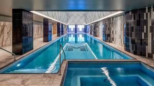 a swimming pool with blue water in a building at Meriton Suites Liverpool in Liverpool