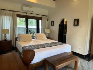 um quarto com uma cama grande e uma janela em Puri Ayu em Canggu