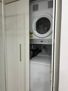 a washer and dryer in a white cabinet at 420 Spacious City Sanctuary Poolgym 2x2 in Perth