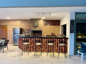 a kitchen with a bar with stools at Vila linda com SPA e Piscina a 50 metros da Praia in Guarujá