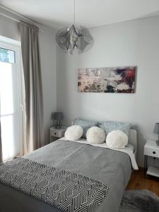 1 dormitorio con cama y lámpara de araña en V71A Kauno Centre, en Kaunas