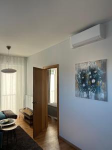 a living room with a couch and a painting on the wall at V71A Kauno Centre in Kaunas