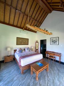 a bedroom with a large bed and a table at Puri Ayu in Canggu +48 photos