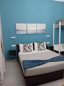 um quarto com uma cama com uma parede azul em JustKey em La Spezia