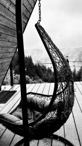 a hammock on a deck with an umbrella at Nordik Cabin - Aframe with 2 bedrooms in Mărişel