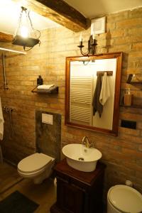 a bathroom with a sink and a toilet and a mirror at Baboško in Rimavská Sobota