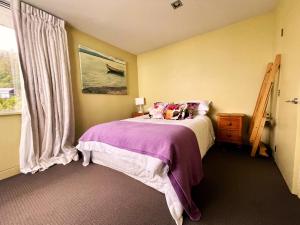 Stunning Views over Tasman Bay في نيلسون: غرفة نوم بسرير ونافذة