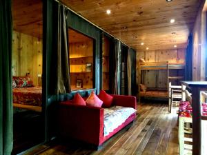 a living room with a couch in a room with wooden walls at GISY Lake House 2F in Lập Trí