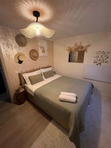 a bedroom with a large bed and a chandelier at Nordik Cabin - Aframe with 2 bedrooms in Mărişel