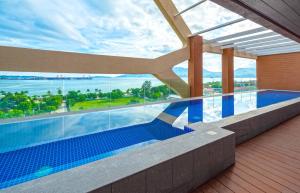 una piscina en un edificio con vistas al océano en The Aurora Subic Hotel Managed By HII, en Olóngapo