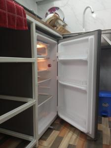 an empty refrigerator with its door open in a kitchen at Paradise Apartment in Mombasa