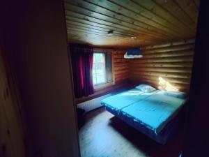 1 dormitorio con 1 cama en una cabaña de madera en Kalliorinteen Mökit Suvipirtti, en Töysä