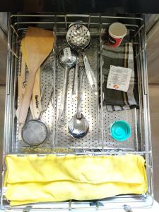 a metal basket with utensils in a drawer at Krishna Nivaas Homestay in Vrindāvan