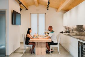 un homme et une femme assis à une table dans une cuisine dans l'établissement Bed & Breakfast dei sogni, à Ascoli Piceno