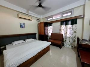 1 dormitorio con 1 cama y 1 silla en Hotel Jora Palace en Jorhāt