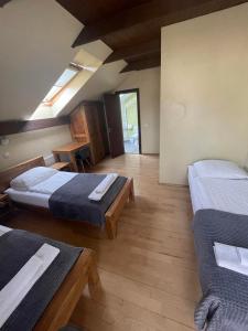 Zimmer mit 2 Betten und Holzboden in der Unterkunft Akmenine Kerpe in Marijampolė