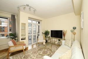 a living room with a white couch and a tv at Spacious 2 bedroom Apartment In Holborn in London