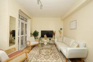 a living room with a white couch and a tv at Spacious 2 bedroom Apartment In Holborn in London +8 photos