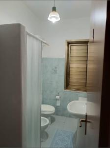 baño con 2 aseos y lavamanos en Sa cronta affitacamere, en Arzana
