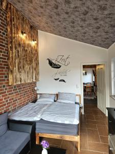 1 dormitorio con 1 cama en una pared de ladrillo en Balzwiekje Auszeit auf Pferdehof in Ostfriesland, en Ihlow