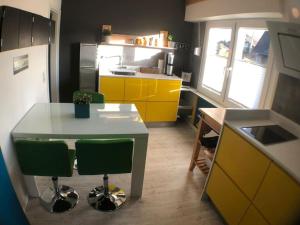 une cuisine avec des armoires jaunes, une table et des chaises dans l'établissement Ferienwohnung Zum Wenning mit Garten in Stadtlohn, à Stadtlohn
