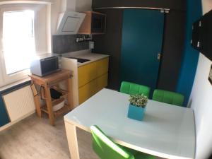 uma pequena cozinha com uma mesa e cadeiras verdes em Ferienwohnung Zum Wenning mit Garten in Stadtlohn em Stadtlohn