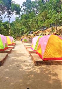 una fila de tiendas coloridas estacionadas en un campo en Ella Camping Resort en Ella