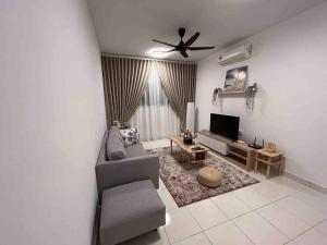 een woonkamer met een bank en een flatscreen-tv bij Alanis B1405 in Sepang