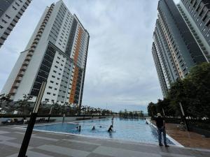 a group of people in a swimming pool with buildings at Alanis B1405 in Sepang