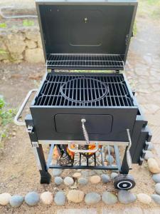 a barbecue grill sitting on the ground with rocks at Вила ОмниЯ in Chernomorets