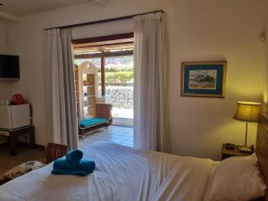 a bedroom with a bed with a blue towel on it at Shanti Ghar Guest House in Tamarin