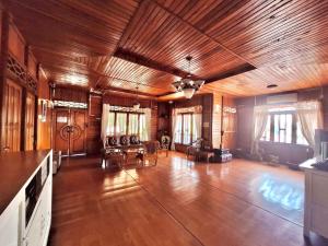 a large room with a wooden ceiling and a living room at Palanta Roemah Kajoe Syariah Villa in Kampungdurian