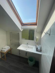 a bathroom with a sink and a skylight at Akmenine Kerpe in Marijampolė