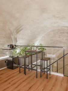 a dining room with two tables and a stone wall at Hydria Rooms in Matera