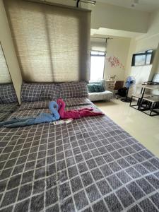 a bedroom with a large bed with a gray comforter at Cozy Studio, super fast internet, workspace and washer in Cebu City