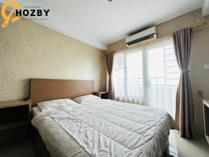 ein Schlafzimmer mit einem großen Bett und einem Fenster in der Unterkunft Skyview Premier Suites Hozby in Sunggal