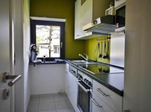 una cocina con fregadero y estufa horno superior en Ferienhaus Diemelquelle - mit eingezäuntem Garten, en Willingen