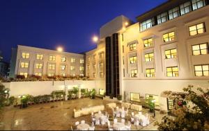 un edificio con un patio con mesas y sillas blancas en Greenpark Hyderabad en Hyderabad