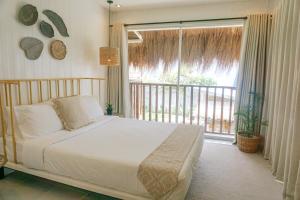 a bedroom with a bed and a large window at Sea Green Boutique Rooms in General Luna