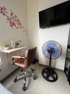 Zimmer mit einem Schreibtisch, einem Ventilator und einem Stuhl in der Unterkunft Cozy Studio, super fast internet, workspace and washer in Cebu City